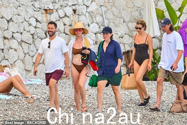 Beaming:Katy 心情很好,因为她和朋友们一起沿着海滩前进