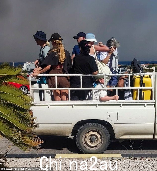 游客坐在后面希腊罗德岛山火期间,露天卡车上的人员疏散