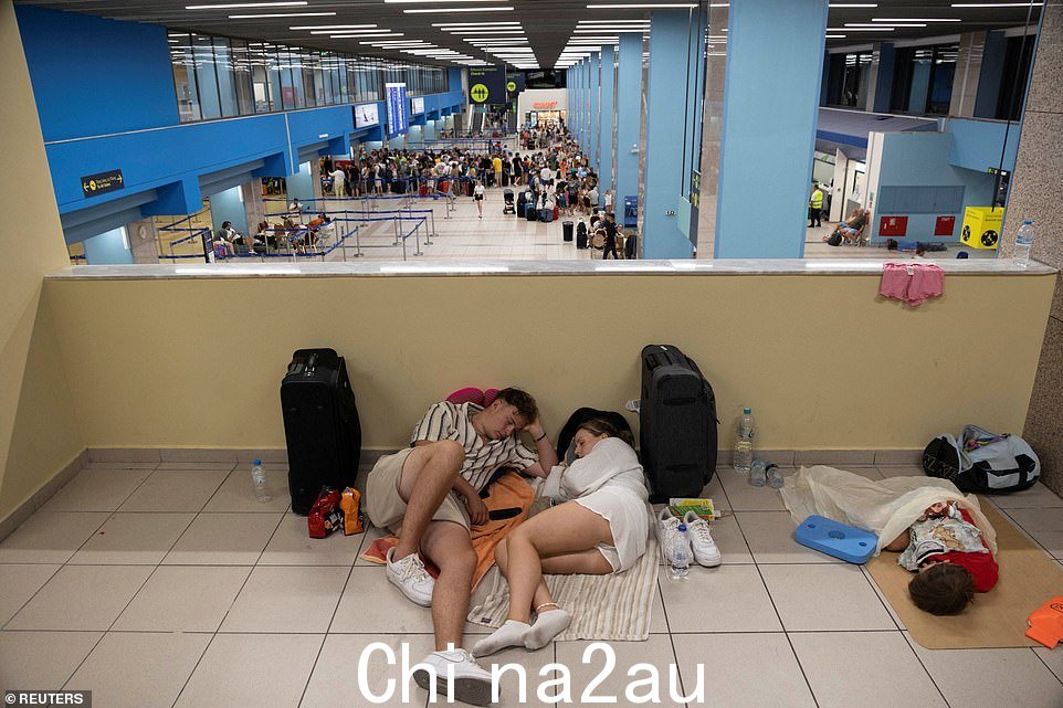 当其他人在值机柜台排队等候时,游客正在睡觉试图回家时在机场离港的飞机