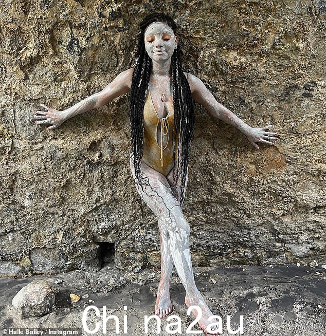 浑身是泥:Halle 穿着深V黄色泳衣,以镂空细节凸显出她的躯干,展现出丰满的身材