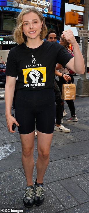 装备:女演员穿着一双黑色出现机车短裤和 SAG-AFTRA 罢工 T 恤