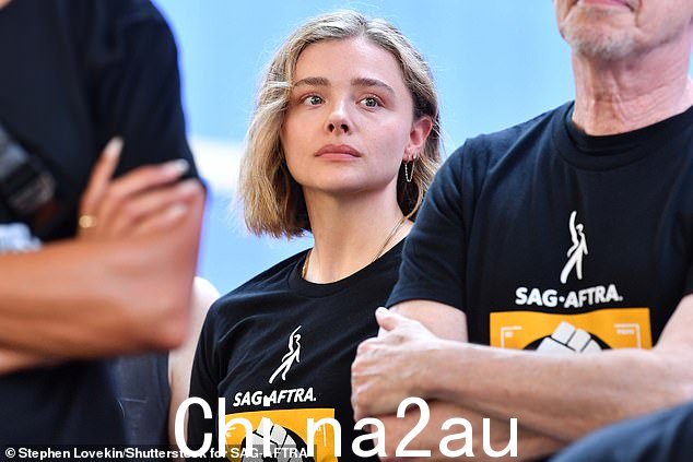 表达支持:克洛伊在抗议活动中与其他人站在一起时穿着配套的黑色 T 恤