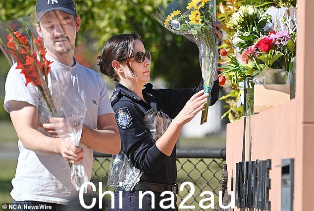警察同事在上周四中午高级警员斯莱德去世的洛根霍姆警察局献花