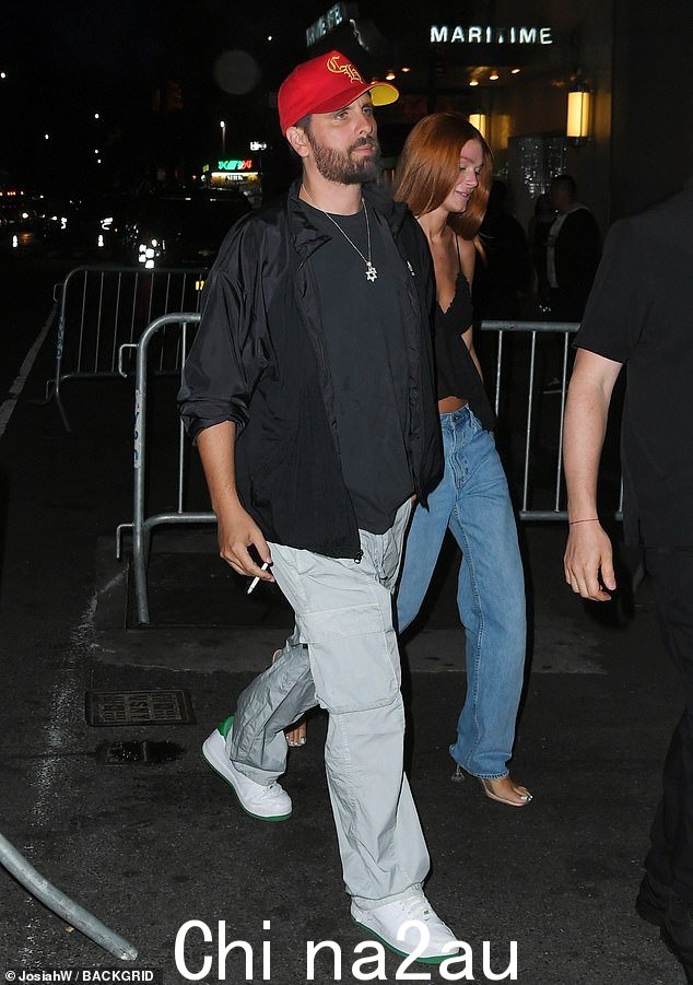 寻找好:Scott Disick,40 岁,穿着灰色工装裤和黑色夹克,搭配红色棒球帽,看起来典型时尚