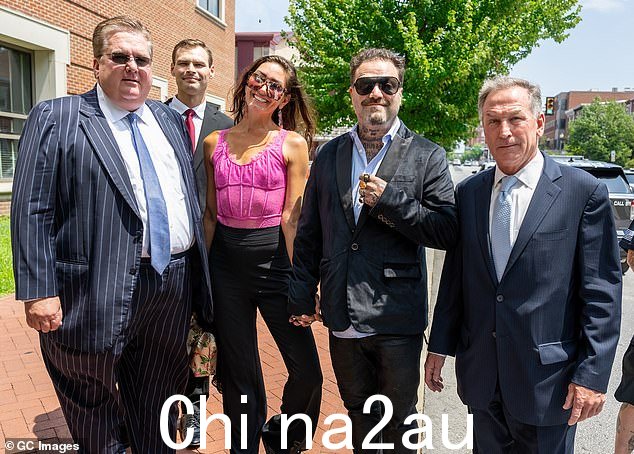 这位 MTV 校友在听证会前与律师一起与丹尼·玛丽 (Dannii Marie) 握手时微笑着
