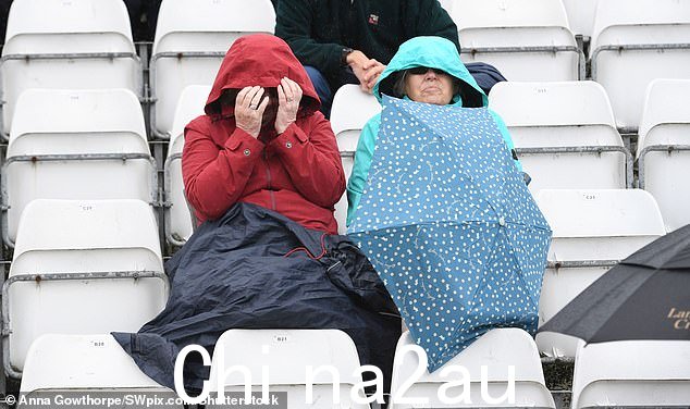 昨天东约克郡斯卡伯勒下雨,人们躲在兜帽下