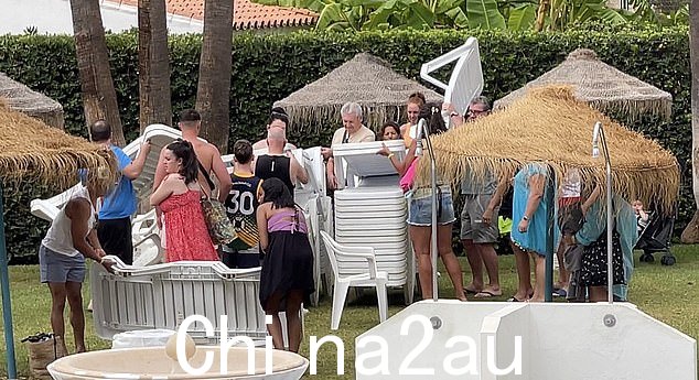 我们出发了!人群走向一排躺椅,在躺椅用完之前抓住它们
