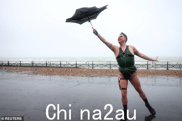 另一位骄傲庆祝者拥抱天气 - 用他们的反面伞摆出姿势