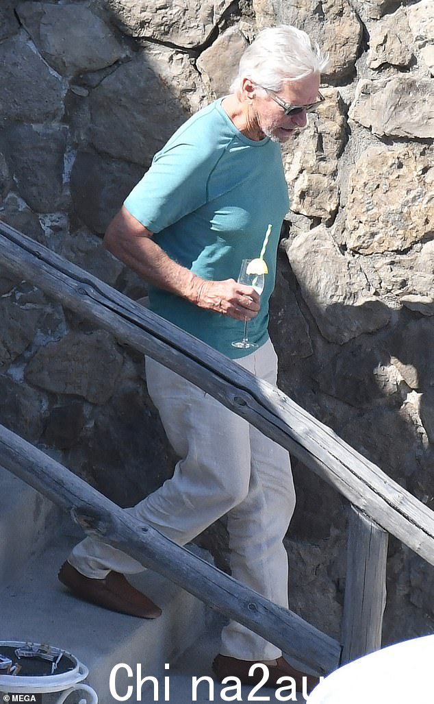 低调:78 岁的迈克尔·道格拉斯 (Michael Douglas) 穿着水色 T 恤,搭配石纹斜纹棉布裤和棕色鞋子,表现得更加休闲