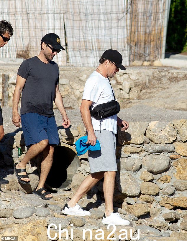 放松:Leo 跳下船时似乎试图不被人注意,他戴着棒球帽遮住了他那张著名的脸