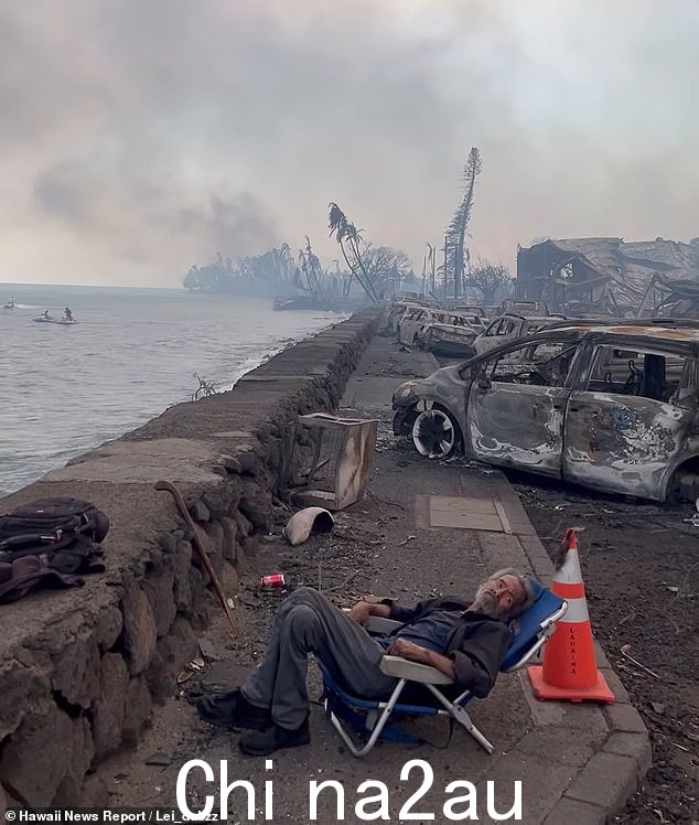 火灾肆虐时在海堤附近拍摄的令人痛心的镜头显示，一位老人疲惫地瘫倒在椅子上，刚刚逃离地狱