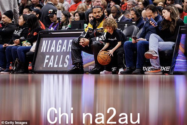未来的全明星:在多伦多猛龙队的比赛中,当阿多尼斯在球场上运球时,这位加拿大音乐家密切关注着他的儿子;见于 2022 年 12 月