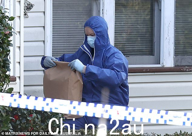 一名身穿全身套装的犯罪现场调查员从家里取出证据袋