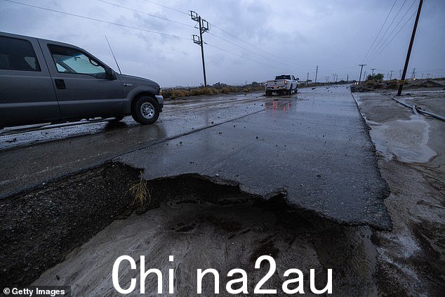 图为昨天南加州沙漠中因热带风暴希拉里山洪而受损的道路