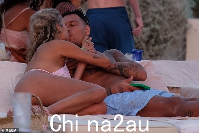打包在 PDA 上:这位 28 岁的比利时模特穿着粉色图案的两件套,在躺椅上与 35 岁的前足球运动员搭档亲密地展示了她迷人的身材。