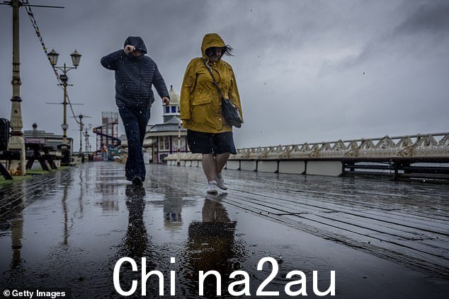 在英国最悲惨的夏天,两个人沿着布莱克浦的北码头散步