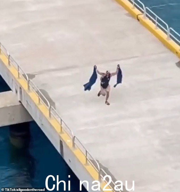 一名男子带着两条沙滩巾得意洋洋地跑下码头,争先恐后地赶上游轮