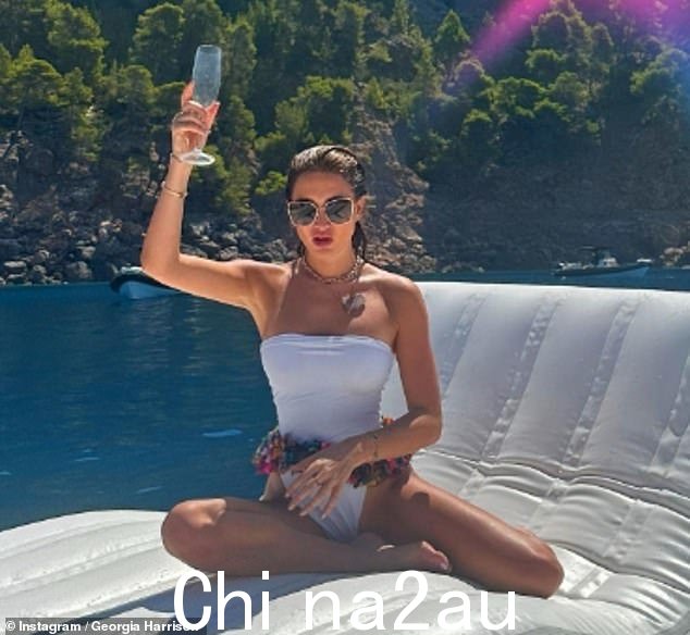 华丽:乔治亚穿着暴露的白色连体衣,在漂浮在海上的巨大充气充气垫上放松,展示了她令人难以置信的身材