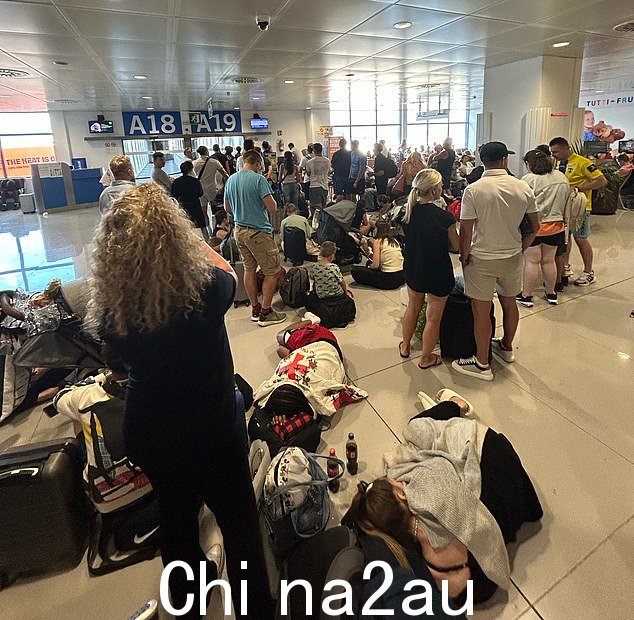 在帕尔马机场内,人们躺在地板上,靠在行李上休息,等待更多航班信息
