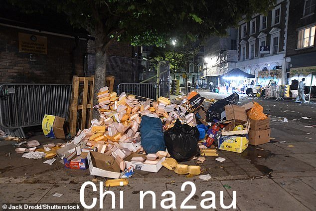 一大堆废弃的外卖盒子坐落在污迹斑斑的人行道一侧