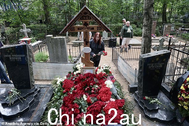 周三,圣彼得堡,一名妇女在因飞机失事丧生的叶夫根尼·普里戈任的坟墓上献花,人们前往墓地悼念