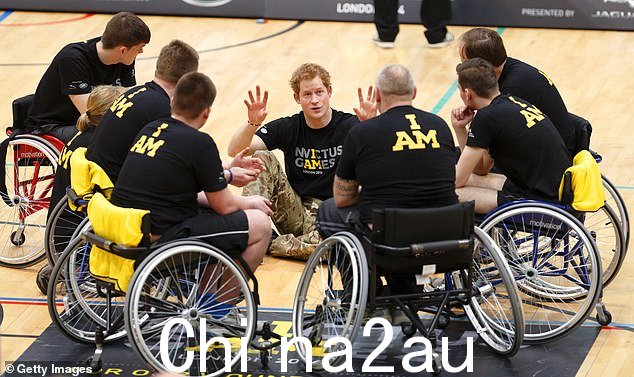哈利在 2014 年 Invictus Games 发布会上与轮椅参赛者交谈