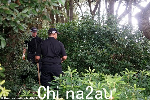 警察在警戒线内搜索一片树林。受害者是一名 49 岁的男子