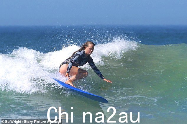 一名冲浪者今天在康沃尔郡 Polzeath 附近的水域充分利用温暖的天气