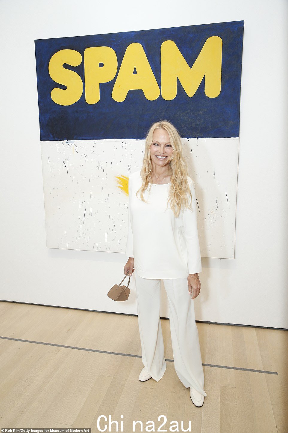 SPAM-ela? 海滩救护队成员帕梅拉·安德森 (Pamela Anderson) 周四在曼哈顿现代艺术博物馆举行的新展览盛大开幕式上,在波普艺术家埃德·鲁沙 (Ed Ruscha) 1962 年的画作《实际尺寸》前摆出姿势。 class=
