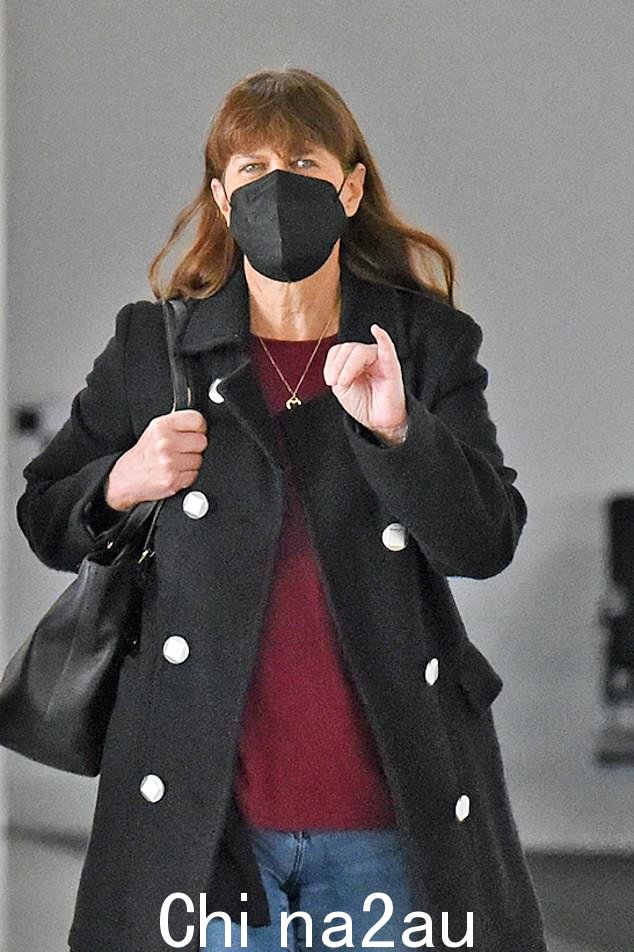 Terri 穿着牛仔裤、栗色衬衫和黑色长外套,看起来很酷但很适合短途飞行