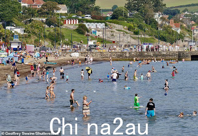家庭在多塞特郡的海滩上享受阳光下的周六