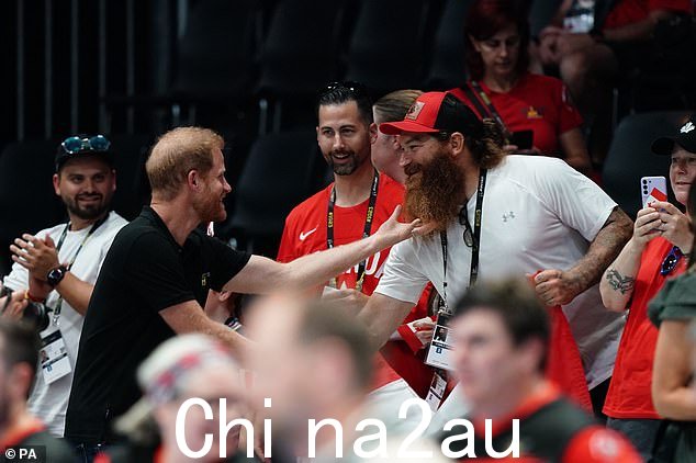 哈里王子首次亮相不败运动会时开玩笑地拉扯一名加拿大球迷的胡须