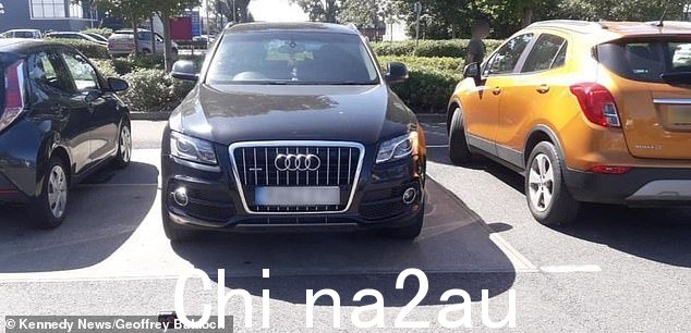 照片显示一辆车停在汽车大小的空间内,两侧还有两辆车