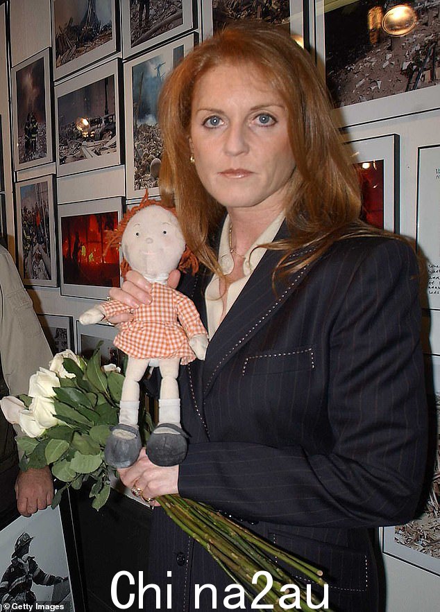 2002 年纽约世贸中心摄影展期间,莎拉·弗格森 (Sarah Ferguson) 与她的慈善吉祥物小红 (Little Red) 合影