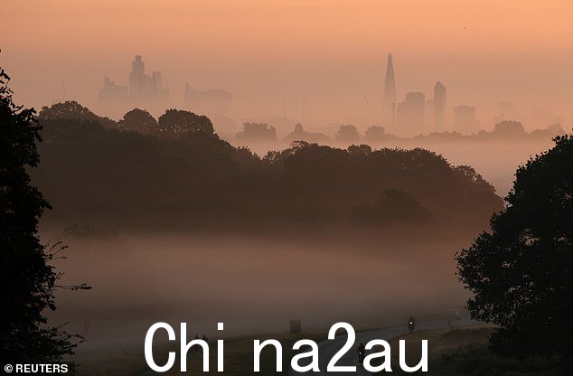 今天日出时分,骑自行车的人在里士满公园骑车穿过雾气,背后是伦敦的天际线