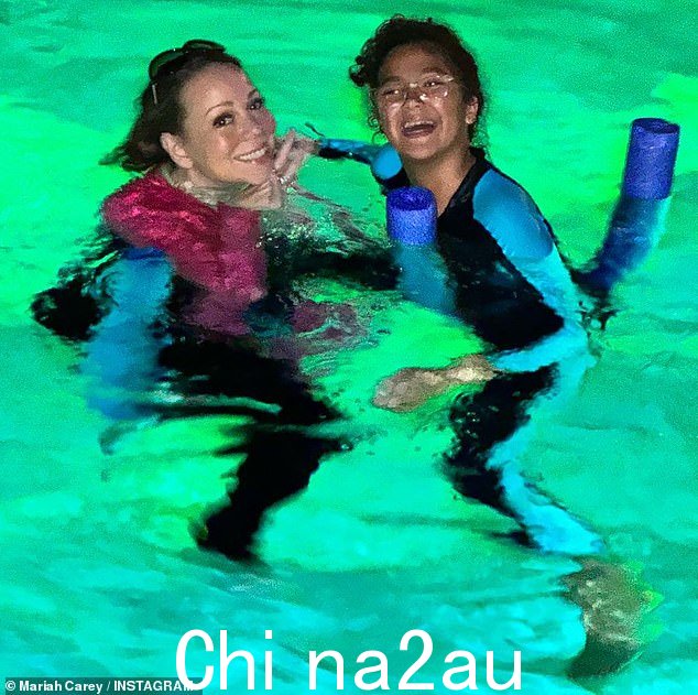 为场合着装:凯莉最终换上了黑粉色泳衣,与女儿一起游泳时的曲线身材紧密贴合