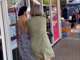 在社交媒体上分享的视频中,一名身穿绿色连衣裙的女子从后面接近 Fyles 女士,然后将奶油甜点推到她脸上。图片来源:TikTok