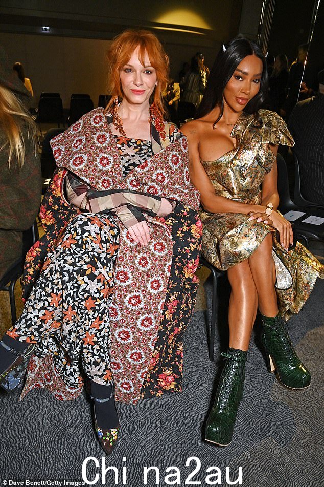 朋友:女演员克里斯蒂娜 (Christina) 与蒙罗·伯格多夫 (Munroe Bergdorf)(右)一起坐在前排,身着引人注目的混合印花连衣裙,搭配相配的斗篷,展现出时尚的身材