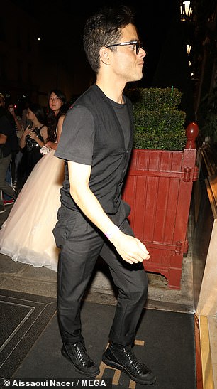 Rami Malek,42 岁,穿着黑色背心,搭配配套 T 恤,身材别致