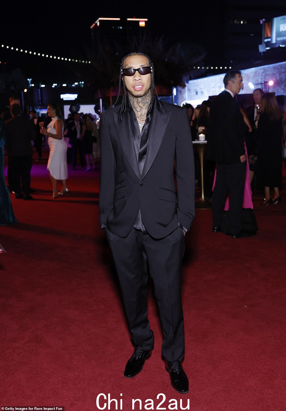 Tyga 在红地毯上出现在摄像机前之前也在场边微笑着