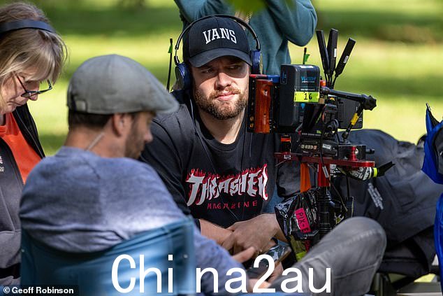在镜头后面:汤姆的样子与他以前的角色截然不同,他胡子拉碴,戴着深色棒球帽,穿着休闲连帽衫