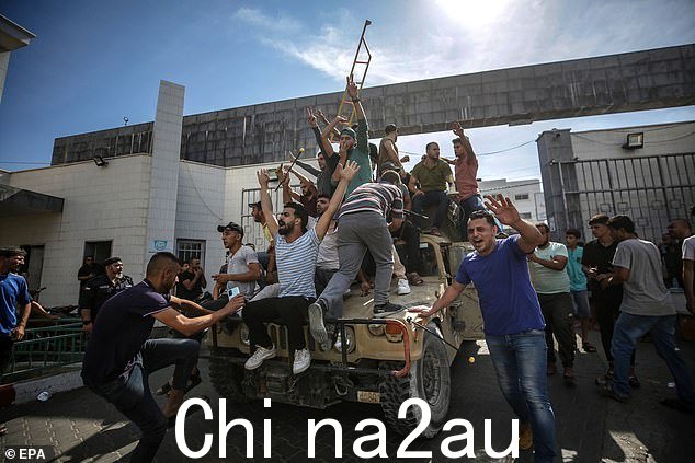 2023 年 10 月 7 日,哈马斯军事派别 Ezz Al-Din Al Qassam 民兵袭击以色列定居点期间,巴勒斯坦人在加沙街头乘坐以色列军用吉普车