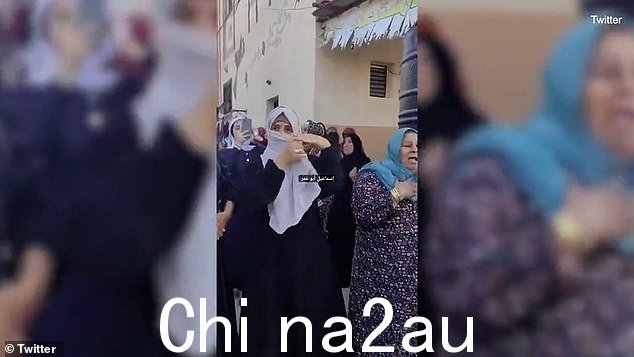 女人在挥舞步枪的兴奋中必须重新调整她的面部遮盖物