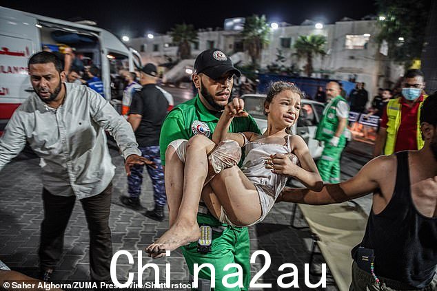 周一,一名护理人员抱着一名小女孩从加沙爆炸现场被拉出来后哭泣