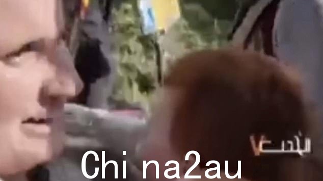 这位母亲拼命地抱住两个年幼的儿子,似乎在向武装分子恳求