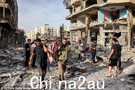 巴勒斯坦男子带走一具尸体2023 年 10 月 11 日，在巴勒斯坦伊斯兰运动哈马斯与以色列激烈战斗的第五天，加沙城卡拉马区一条满是废墟的街道上，以色列人轰炸身亡。在加沙伊斯兰主义者发动海陆空袭击后，以色列于 10 月 8 日向哈马斯宣战。哈马斯武装分子发动的令人震惊的跨境袭击造成的死亡人数上升至 1,200 人，成为该国 75 年历史上最致命的袭击，而加沙官员报告称，以色列空袭该地区已造成 900 多人死亡。 （穆罕默德·阿贝德/法新社拍摄）（穆罕默德·阿贝德/法新社通过盖蒂图片社拍摄）