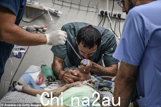 加沙的医务人员表示,由于发电机难以维持基本机器的供电,人们依靠生命维持的时间已经不多了。图:医生在汗尤尼斯的纳赛尔医院检查一名儿童