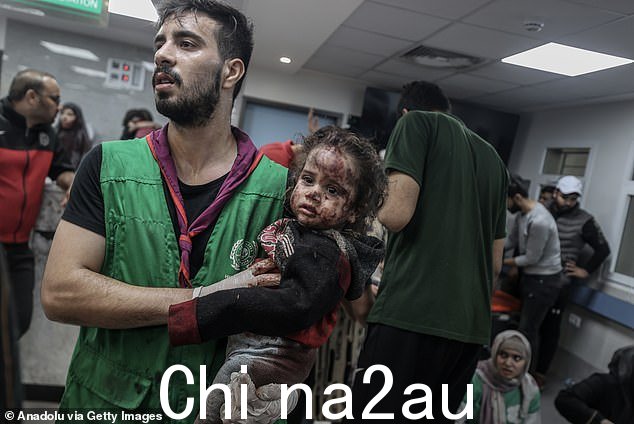 周二，加沙市 Al-Ahli Baptist 医院遭受空袭后，一名受伤的幼儿被一名明显的医务人员抱起