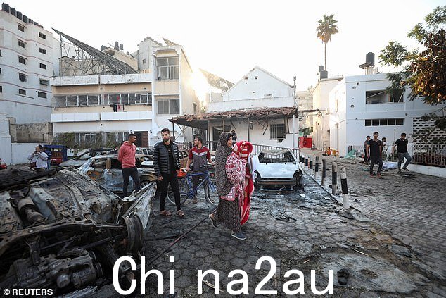 人们检查 Al-Ahli 医院区域,周三,以色列和巴勒斯坦官员互相指责对方发生爆炸,导致数百名巴勒斯坦人丧生