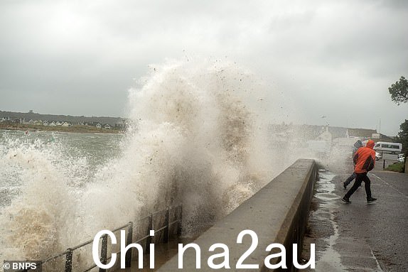 BNPS.co.uk (01202) 558833。图片：BNPS Storm巴贝特输入 - 预计今天会有更强风和大雨。人们在多塞特郡穆德福德码头看到巨浪冲向海岸时躲避浪花